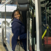 Woman steps onto a city bus.