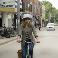 Woman confidently riding her bike downtown.